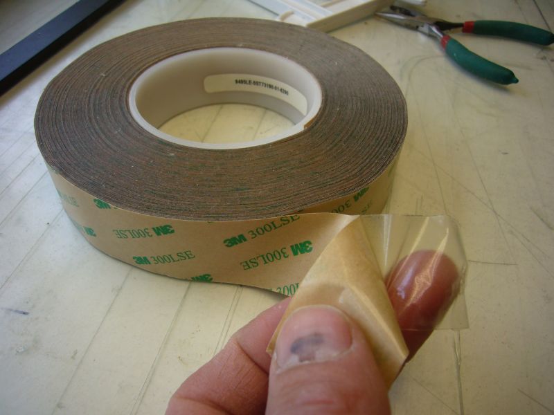 Dubbelzijdig tape 3M 300LSE
Dikte van de kleeftape ca. 0,15mm
De tape laat dus niet alleen een lijm achter, het is een transparante, iets elastische plastic drager met aan weerszijden lijm.
