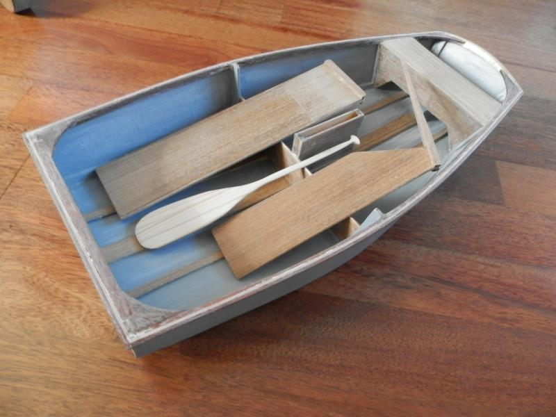 Het schuren van de geverfde bodemlatten en mastdoft bracht verbetering, maar niet tot tevredenheid. In het bijzonder in de hoeken bleven witte grondverfresten in de houtnerven zichtbaar. Daarom besloten over de bodemlatten, kielbalk en mastdoft teakfineer aan te brengen. Met tevredenstellend resultaat. Ook het roer en het zwaard met teak gefineerd, waarmee het een stijlvol scheepje gaat worden.  Je zou er zo mee wegpeddelen ...